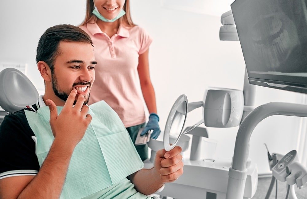 man at a dentist cabinet having teeth repaired